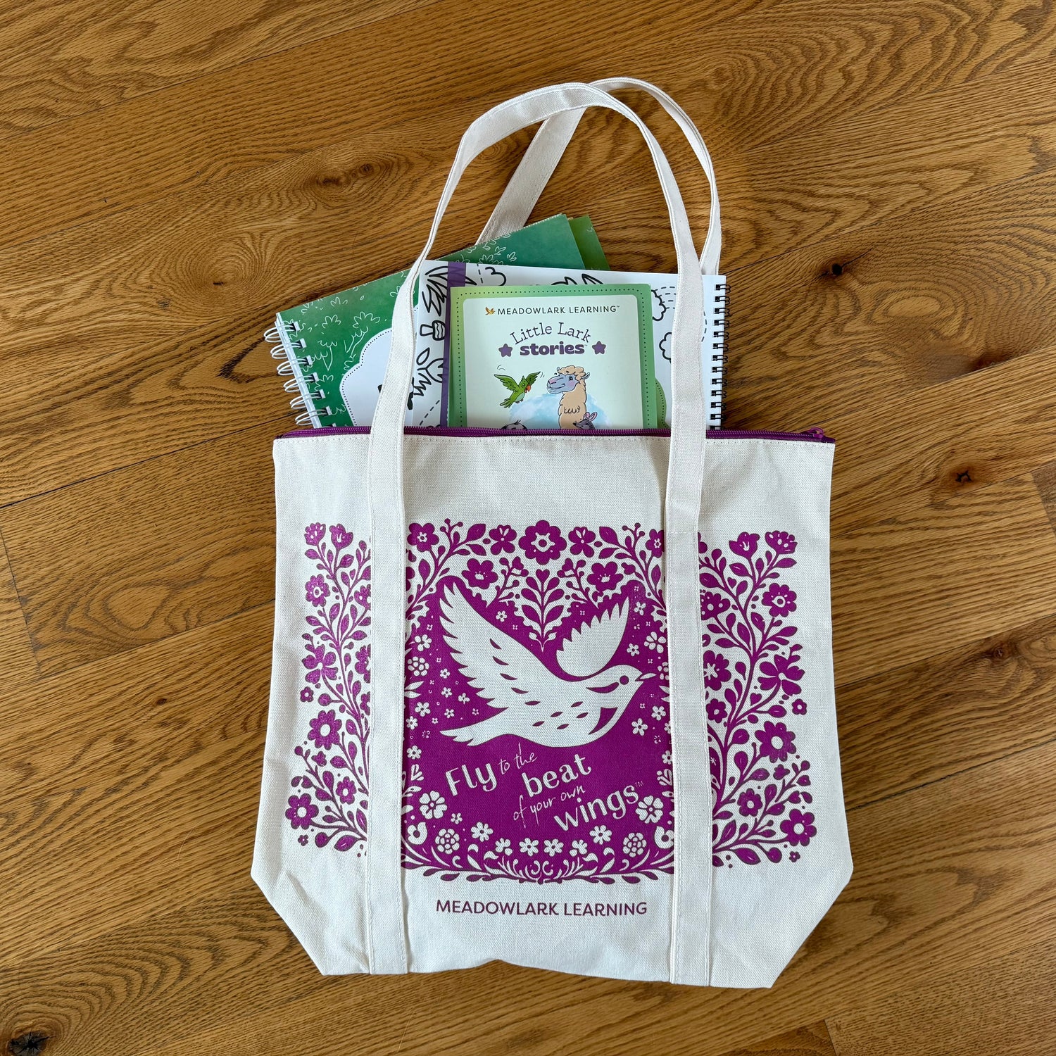 Tote bag with purple design and text on a wooden surface