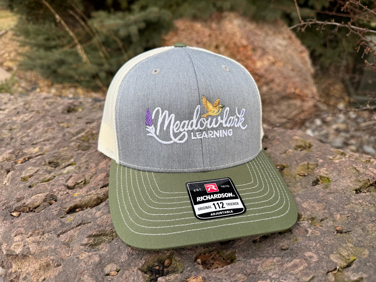 Gray and green cap with 'Meadowlark Learning' logo on a stone surface